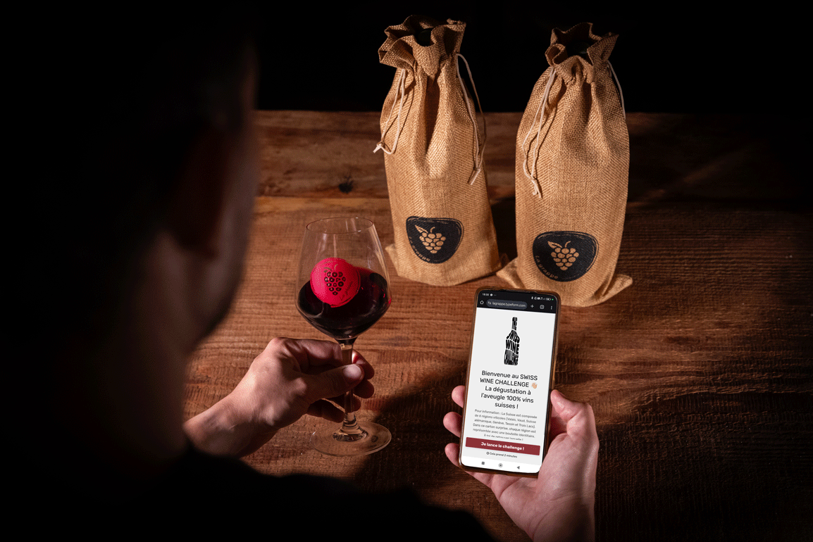 Une personne déguste du vin et joue sur son smartphone